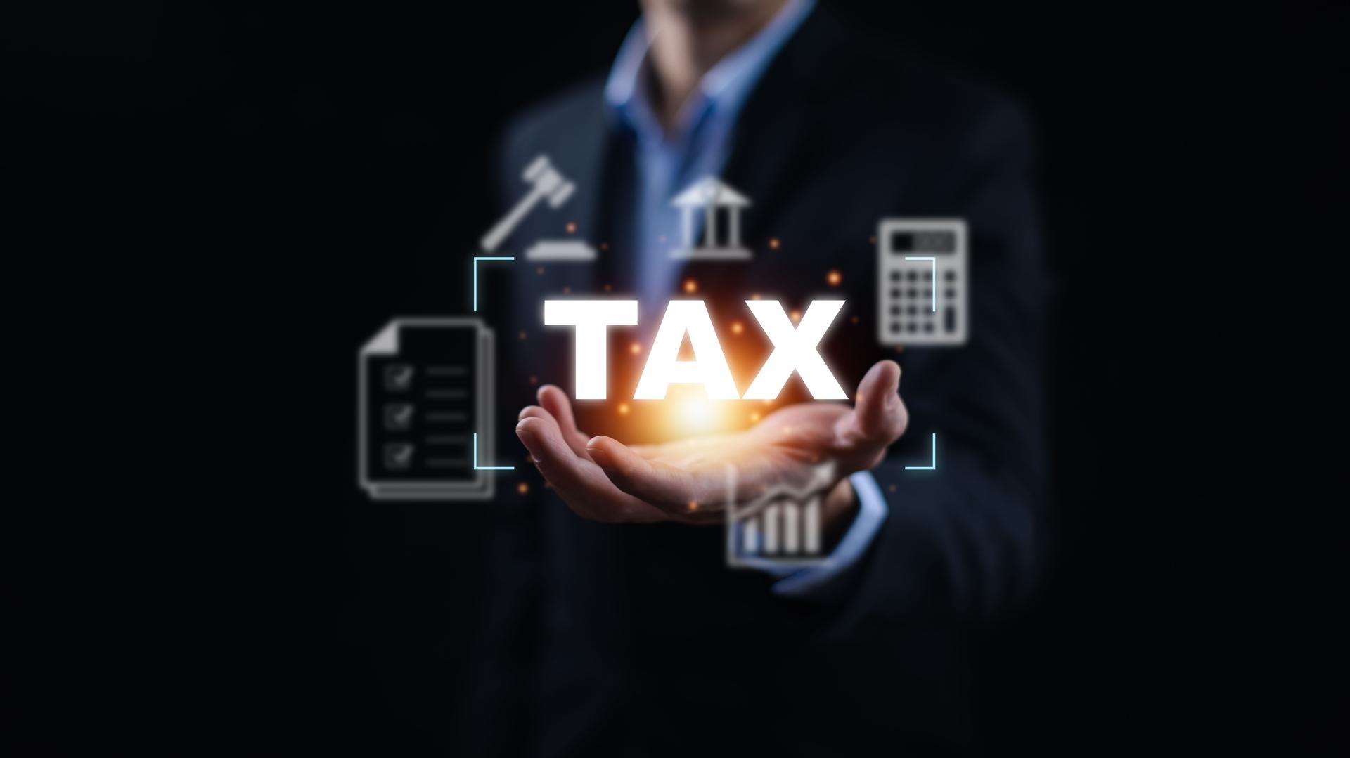 Concept of taxes payment optimisation business finance, Businessman holding taxes button on technology screen,income tax and property, background for business, individuals and corporations such as VAT